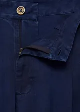 Pantalon de corte wide leg, tiro medio, con cierre frontal de cremallera y botón, detalle de pinzas y bolsillos laterales.