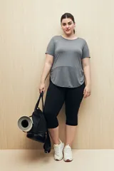 Remera deportiva color lila de manga corta con calce relajado y corte horizontal en la parte inferior.