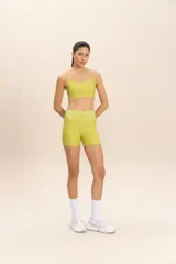 Top deportivo color verde lima con tirantes finos y estampado de la palabra "LIVE" en relieve. Incluye relleno extraíble y está confeccionado en tejido Sense Pro® con tecnología Easy Care y protección UV50+.