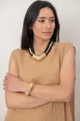 Vestido midi de lino color beige, sin mangas y con cuello redondo. Cuenta con un diseño irregular con detalle de volado vertical a un costado.