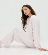 Pijama largo Lov de plush color rosado, compuesto por una blusa de manga larga con cuello redondo y un pantalón largo de corte regular con cintura elástica. Ambas piezas cuentan con apliques de encaje en los laterales de las mangas y de las piernas.