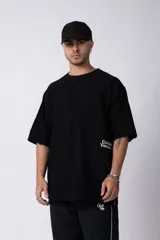 Remera de corte oversize color negro, con cuello redondo y mangas cortas. Presenta un pequeño estampado en color blanco en la parte inferior lateral con la frase 'Curbside Treasures'.