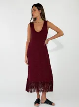 Vestido midi de punto color bordó con acabado brillante, sin mangas, escote en V y detalle de flecos en el ruedo.