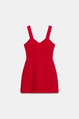 Vestido corto de color rojo con escote corazón estilo corsetero, tirantes anchos y falda con corte evasé. Cuenta con cierre de cremallera oculto en la espalda.