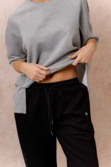 Pantalón gris melange de calce relajado y pierna amplia, con cintura elastizada y cordón regulable. Cuenta con bolsillos laterales y tejido de tacto suave.