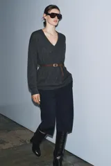 Jersey oversize de lana con escote en pico y manga larga. Incluye un cinturón fino de cuero en tono marrón con hebilla metálica dorada.