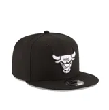 Gorra New Era modelo 9Fifty, color negro con el logotipo bordado de los Chicago Bulls en la parte frontal en color blanco. Cuenta con visera plana y cierre ajustable en la parte trasera.