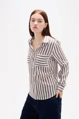 Camisa de viscosa con estampado de rayas verticales, cuello camisero, cierre frontal de botones y bolsillo en el pecho.