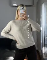 Sweater de punto con cuello redondo y mangas largas, con diseño de textura acanalada en los laterales y mangas. Presenta un corte holgado y cómodo.
