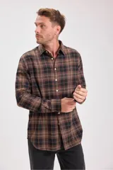 Camisa de manga larga con cuello y botones, confeccionada en tejido de franela a cuadros en tonos verde oscuro, azul marino y marrón.