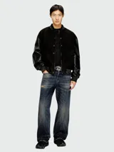 Campera estilo bomber Diesel modelo L-Nyn, color negro, con cuerpo de cuero texturizado y mangas de cuero liso, cierre frontal con broches a presión y cuello, puños y dobladillo de punto elástico rayado.