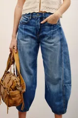 Jean de tiro medio-alto y calce holgado, con piernas anchas que se estrechan hacia el tobillo y largo midi. Confeccionado en denim rígido con lavado bleach y cierre frontal con botones.