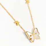 Collar dorado con cadena fina y dije de mariposa de nácar, con cuatro dijes de mariposas pequeñas doradas.