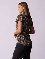 Remera tejida con estampado animal print, de manga corta con detalle de puntilla en las mangas y cuello redondo.