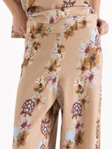 Pantalón East de tiro alto y botamanga amplia, confeccionado en morley liviano con estampado floreado. Presenta cintura estructurada con elástico y tablas en el lateral.