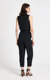 Pantalón sastrero de corte recto y tiro alto, confeccionado en tejido de punto con estampado de raya diplomática. Presenta cintura estructurada con trabillas, pliegues frontales, bolsillos traseros de ribete y cierre frontal con cremallera y corchetes.