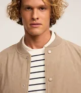 Campera bomber azul marino de pana con cuello redondo, cierre con botones a presión, bolsillos laterales y puños y cintura elastizados.