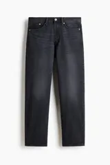 Jean de cinco bolsillos en denim de algodón rígido, color negro con efecto deslavado. Modelo con pierna recta y corte estándar de cintura a bajo, con cierre de botones.