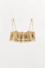 Top corto de escote recto con tirantes finos ajustables mediante lazadas. Presenta un diseño de tejido superpuesto tipo volante con bordados florales y detalles de abalorios a contraste. Cuenta con cierre posterior mediante botones forrados.