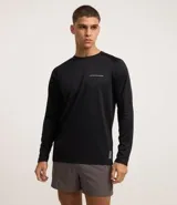 Remera deportiva negra de poliéster con tecnología Dry, cuello redondo, manga larga y estampa lettering en el pecho.