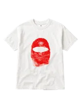 Remera blanca de manga corta con estampa frontal en color rojo que representa una máscara tipo pasamontañas con textura de huella dactilar y un pequeño logo circular en la parte superior.