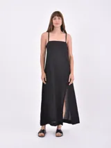 Vestido largo negro de lino con tirantes finos, escote recto y tajo lateral en la falda.
