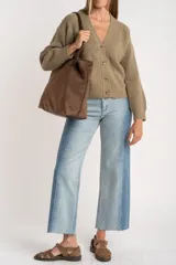 Cardigan de punto acanalado con cuello en V y cierre frontal de botones. Presenta un corte oversize y mangas largas con puños ajustados.