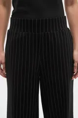 Pantalon de vestir de corte recto y tiro alto, confeccionado en tela de viscosa con diseño de rayas verticales finas en color blanco sobre fondo negro.