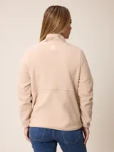 Canguro de sherpa color bordó, con cuello alto y cierre frontal parcial. Presenta un bolsillo con cierre en el pecho y bolsillos laterales, confeccionado en tejido de textura suave y abrigada.