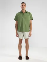 Short de baño para hombre con estampado de rayas verticales finas en tonos blanco y verde. Confeccionado en tejido liviano, elástico y de secado rápido. Cuenta con cintura elástica con cordón regulable, bolsillos laterales y trasero con cierre. Incluye suspensor de malla fina hipoalergénico.