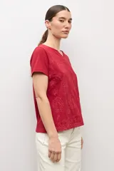 Remera marrón camel de manga corta, con cuello en V y diseño de estampado floral con relieve.