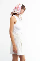 Minifalda color beige de lino y viscosa, con corte cruzado, lazo lateral y bolsillo tipo cargo.