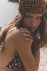Gorro tipo casquete de tejido trenzado con diseño de red, en color marrón oscuro.
