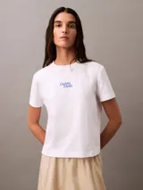 Remera blanca de algodón con cuello redondo y logo Calvin Klein aterciopelado en azul.