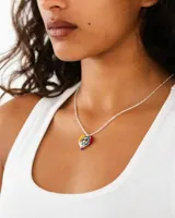 Collar de cadena fina plateada con dije en forma de corazón esmaltado con los colores del arcoíris y el símbolo de la paz en el centro.
