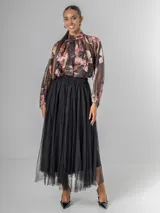 Falda estilo ballet core confeccionada en gasa negra con pequeños destellos que aportan brillo sutil y movimiento. Tiene cintura elastizada.