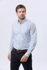 Camisa de manga larga con diseño a cuadros en tonos celeste, azul y blanco, con cuello abotonado y cierre frontal con botones.
