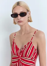 Vestido midi de tirantes finos ajustables, con escote en pico y detalle fruncido en la parte frontal. Presenta un diseño recto con estampado de rayas verticales en tonos rojo y blanco.