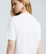 Remera de algodón color blanco, con cuello redondo y mangas cortas. Presenta un estampado frontal de dos ositos con vestimenta urbana y tipografía en tonos azules y rojos.