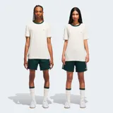 Camiseta Adidas Originals de corte holgado, color blanco con cuello redondo acanalado en color verde oscuro. Presenta un diseño sutilmente texturizado y el logo del trébol bordado en el pecho.