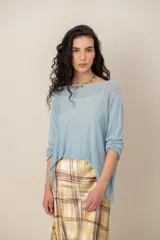 Sweater de punto celeste, de corte holgado, con escote bote y mangas largas.