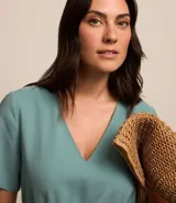 Vestido corto de Marfinno confeccionado en viscosa, con escote en V, mangas cortas y cierre frontal tipo gota. Incluye trabillas y un cinturón de tela ajustable con detalle de abalorios en los extremos.