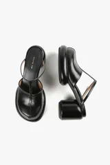 Mules de cuero color blanco con diseño moderno, taco ancho y plataforma. Cuenta con una tira superior negra que aporta estabilidad y un calce cómodo.