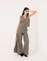 Chaleco de vestir gris oscuro con textura tipo tweed, escote en V y botones frontales. Corte levemente entallado y largo a la cintura.