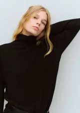 Vestido corto de punto con cuello alto y manga larga, de diseño recto y estilo minimalista.