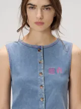 Musculosa MUTMA Trebola de silueta recta confeccionada en tejido de punto color gris con efecto lavado. Posee cierre frontal con botones, detalle de bordado en el pecho y terminación festoneada en el ruedo y las sisas.
