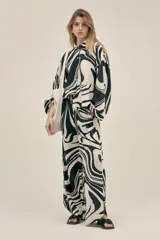 Pantalón ancho con estampado abstracto en blanco y negro, con pinzas en el frente, bolsillos laterales y elástico en la cintura.