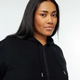 Buzo negro con capucha y cierre frontal, de corte holgado.