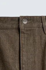 Pantalón de corte regular fit confeccionado en tejido ligero de algodón color marrón. Presenta diseño clásico de cinco bolsillos, cierre frontal con cremallera y botón metálico.