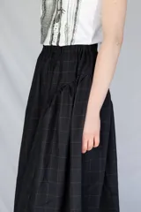 Falda midi de corte amplio con cintura elastizada y frunces laterales, confeccionada en tejido tipo gobelino con estampado floral sobre fondo azul.